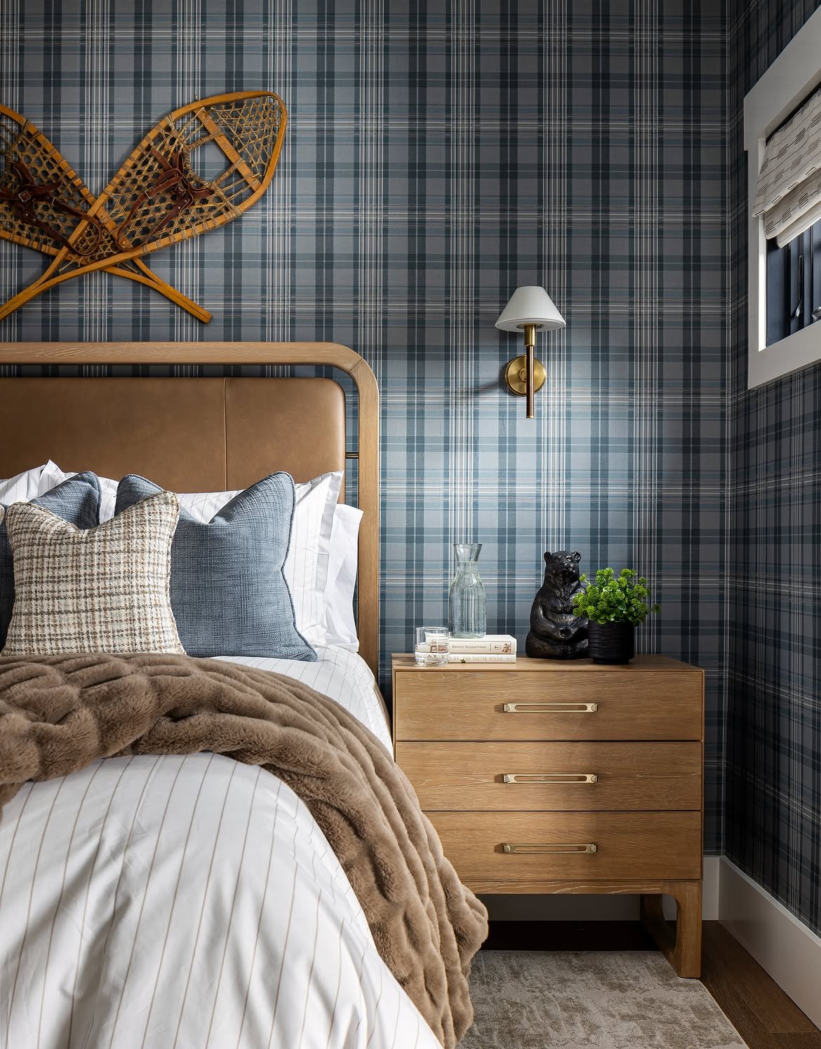 A cozy retreat layered in plaid and leather textures. Vintage snowshoes mountain accents and r